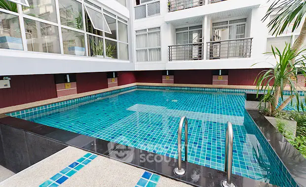 Luxurious apartment complex with a stunning swimming pool and modern architecture.