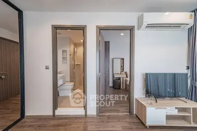 Modern apartment interior with sleek design, featuring a bathroom and living area with air conditioning.
