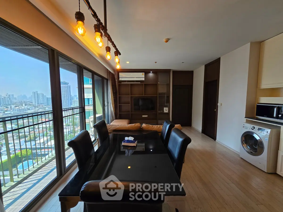 Spacious living room with city view, modern furniture, and natural light in a high-rise apartment.