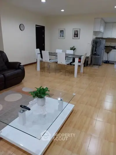 Spacious modern living room with dining area and open kitchen, featuring elegant furniture and stylish decor.