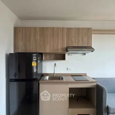Modern compact kitchen with sleek cabinetry and integrated appliances in a cozy apartment.