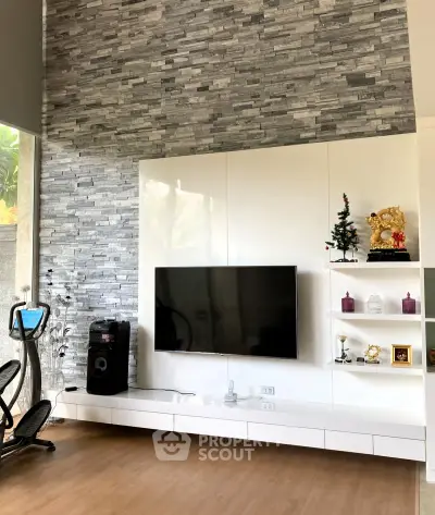Modern living room with sleek TV setup and stylish stone accent wall