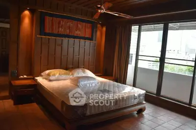 Luxurious bedroom with wooden accents and large window offering city views.