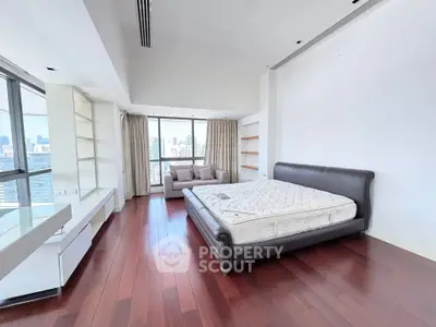 Spacious bedroom with city view and elegant hardwood flooring