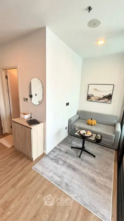 Modern living room with cozy sofa, stylish decor, and wooden flooring in a bright apartment.