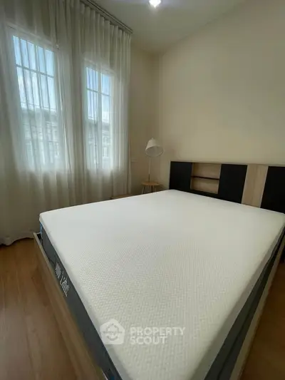 Cozy bedroom with natural light and modern furnishings, perfect for relaxation and comfort.