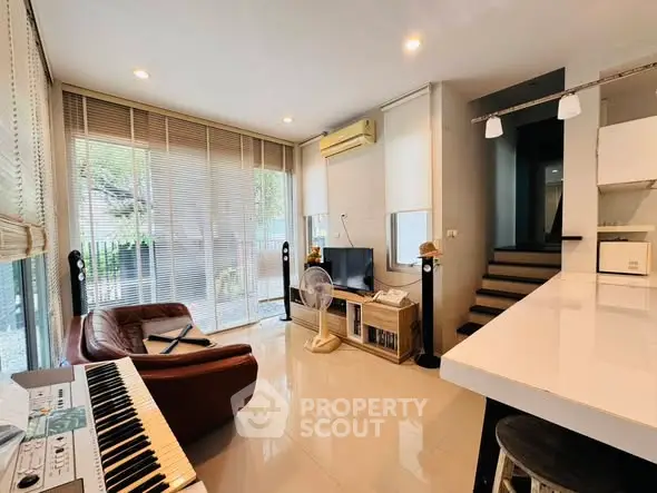 Modern living room with sleek design, featuring large windows, stylish furniture, and a cozy ambiance.