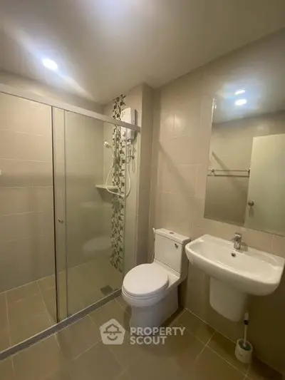 Modern bathroom with glass shower enclosure and sleek fixtures