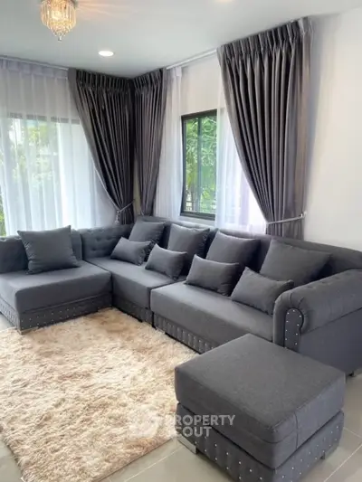 Elegant living room with plush gray sectional sofa and soft rug, perfect for relaxation and entertaining.