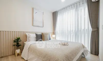 Bright and cozy bedroom with elegant decor and large window for natural light.