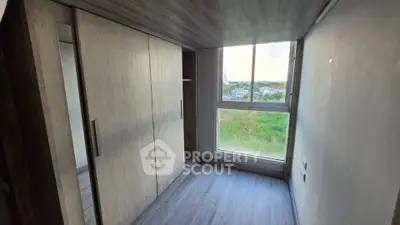 Compact bedroom with large window and built-in wardrobe offering scenic views.