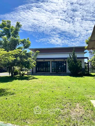 Modern building with lush green lawn and clear blue sky