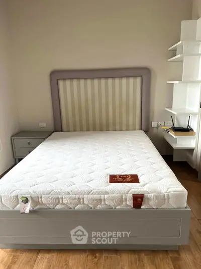 Spacious bedroom with modern bed and built-in shelves, perfect for comfortable living.