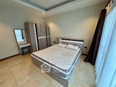 Spacious bedroom with modern furniture and ample natural light.