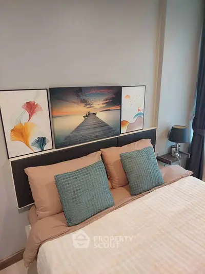 Cozy bedroom with stylish decor and serene artwork above the bed, perfect for relaxation.
