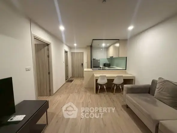 Modern open-plan living room with sleek kitchen and cozy seating area