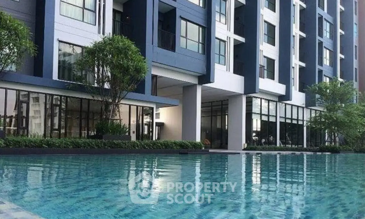 Modern apartment building with a luxurious pool and lush greenery, perfect for urban living.