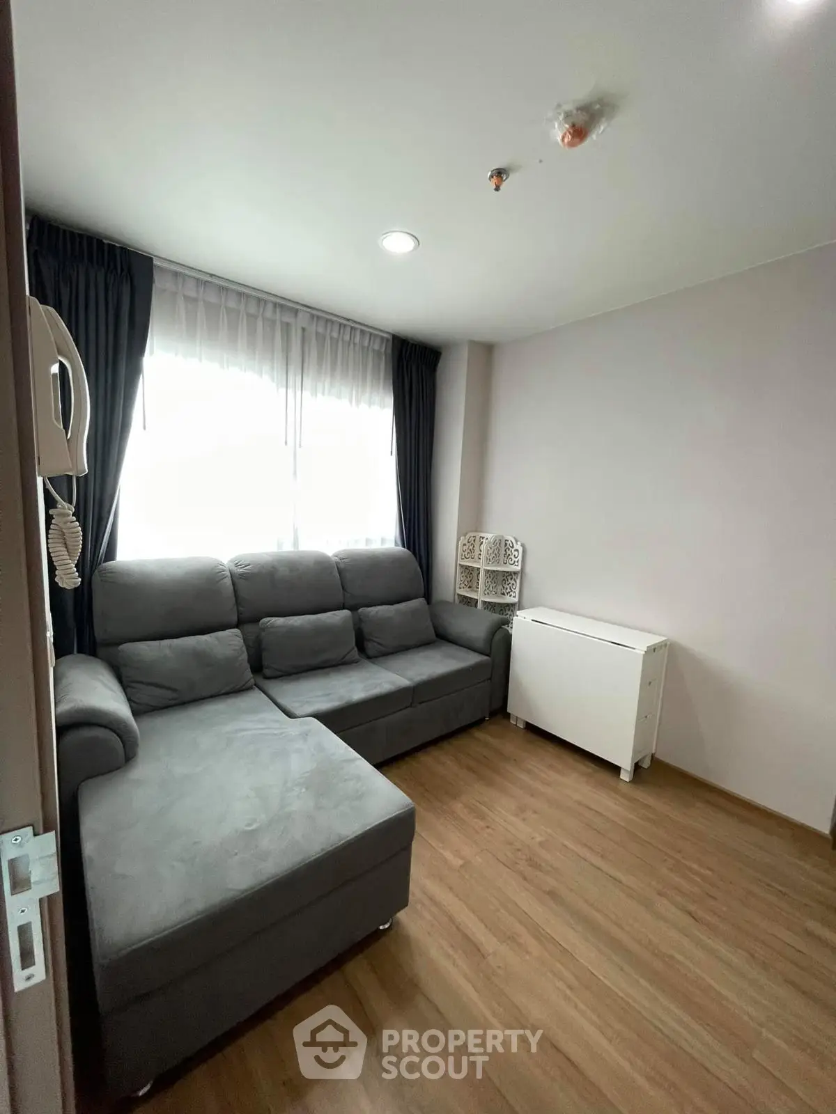 Cozy living room with gray sectional sofa and wooden flooring