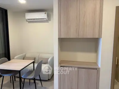 Modern apartment interior with sleek dining area and built-in storage, featuring minimalist design and neutral tones.