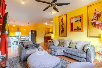 Vibrant living room with modern decor and open layout, featuring stylish furniture and bright yellow walls.