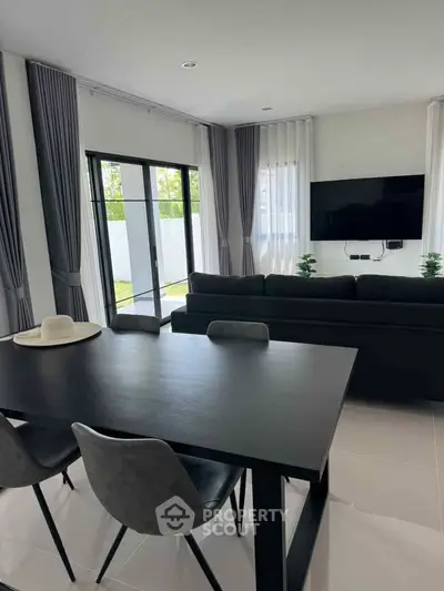 Modern living room with sleek furniture and large windows for natural light.