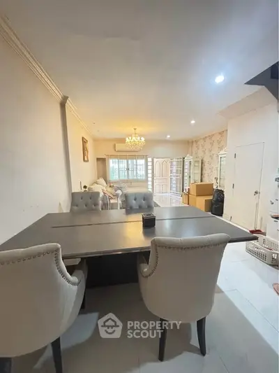 Spacious living room with elegant dining area and chandelier lighting.