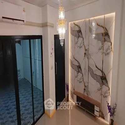 Luxurious interior with marble accent wall and elegant chandelier lighting