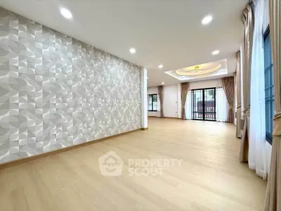 Spacious modern living room with elegant wallpaper and large windows for natural light.