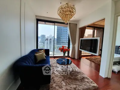 Luxurious living room with chandelier and city view, featuring elegant decor and plush furnishings.