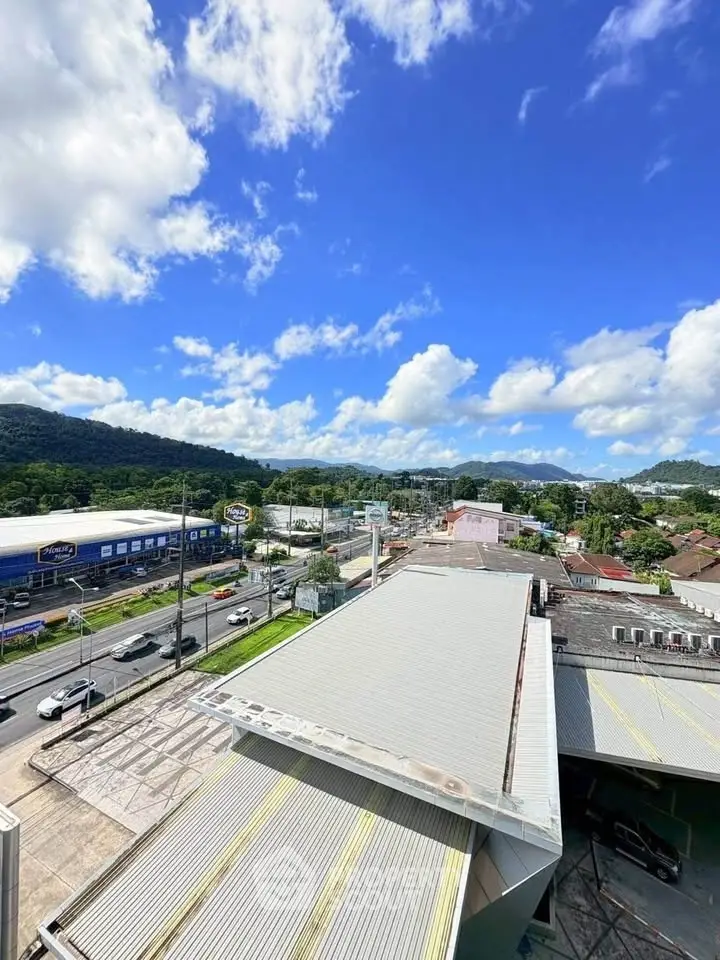 Stunning aerial view of commercial buildings with lush green hills and clear blue sky.