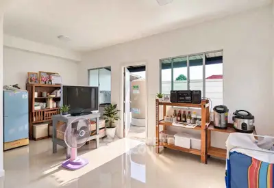 Bright and airy living room with modern appliances and sleek furniture, perfect for comfortable living.