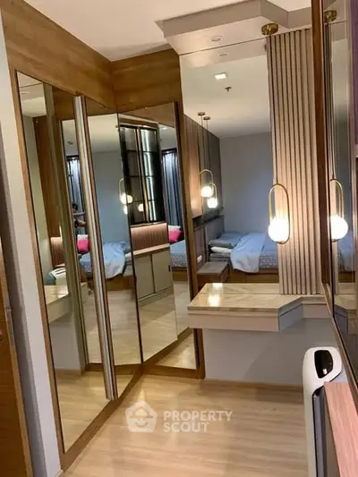 Luxurious bedroom with mirrored wardrobes and elegant lighting in modern apartment.