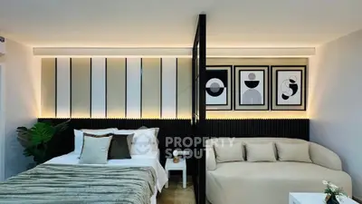 Modern bedroom with stylish decor and cozy seating area, featuring elegant wall art and ambient lighting.