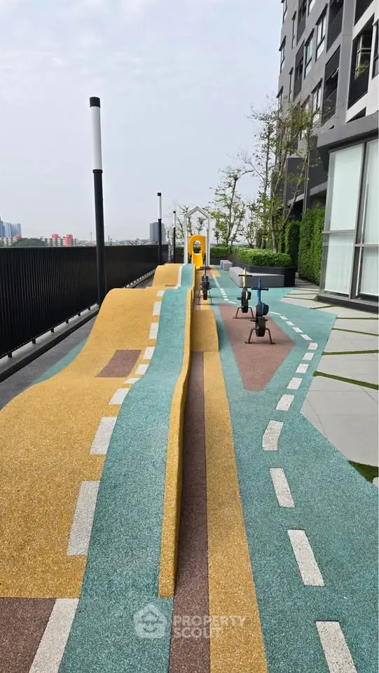 Modern apartment building with outdoor playground and unique design features.