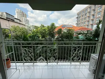 Charming balcony with lush greenery and city view, perfect for relaxation.