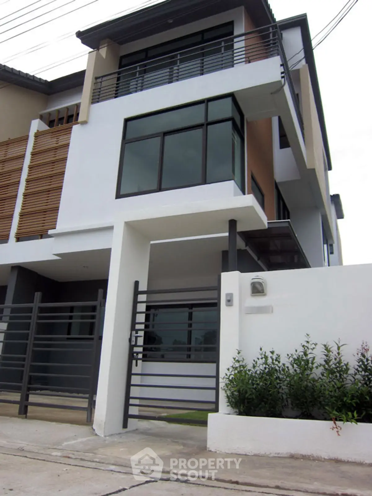 Modern multi-story townhouse with sleek design and gated entrance