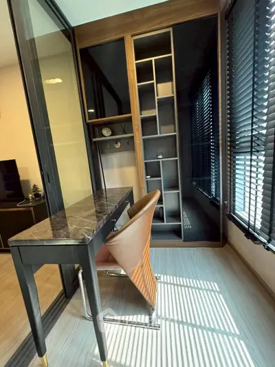Modern study area with sleek desk and chair, large windows with blinds, and built-in shelving unit.