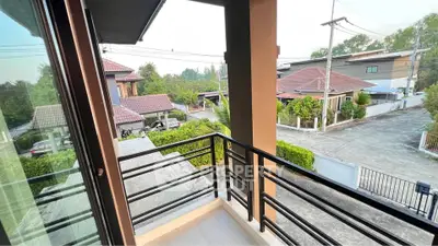 Charming balcony view overlooking a serene residential neighborhood with lush greenery.