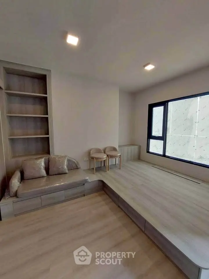 Modern minimalist living room with built-in shelving and large window
