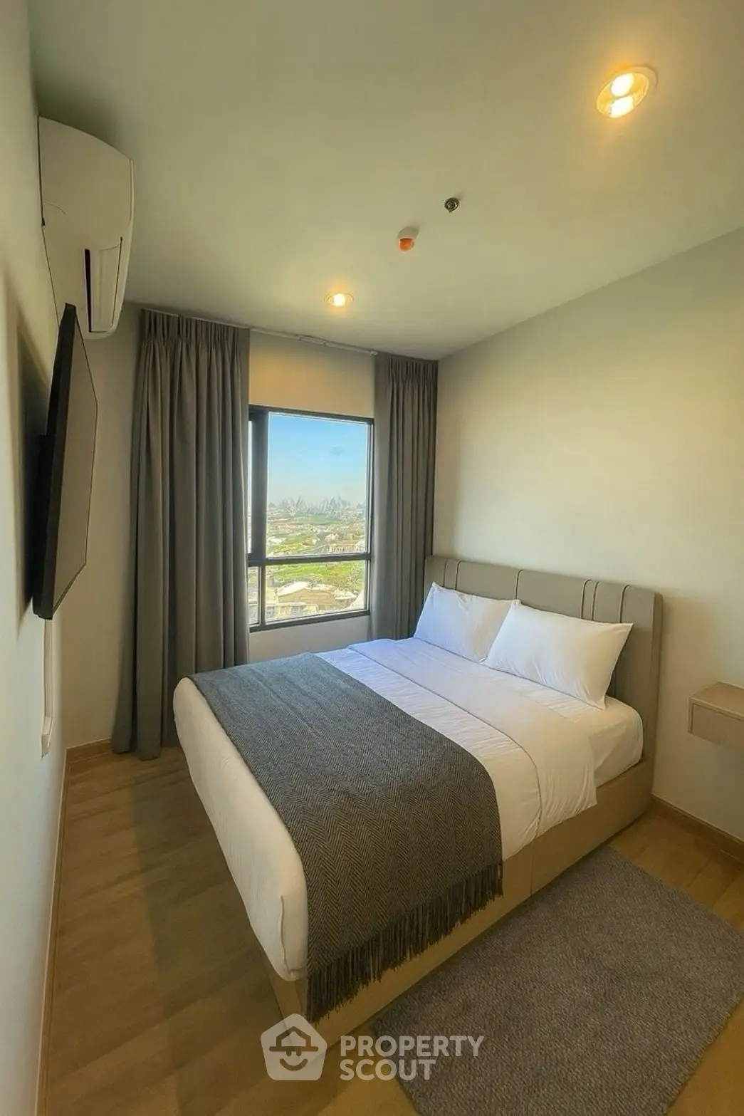 Modern bedroom with large window and scenic view, featuring a cozy bed and stylish decor.