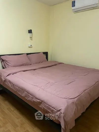 Cozy bedroom with pink bedding and modern air conditioning unit, perfect for restful nights.