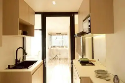 Modern kitchen with sleek cabinetry and open layout leading to a bright dining area.