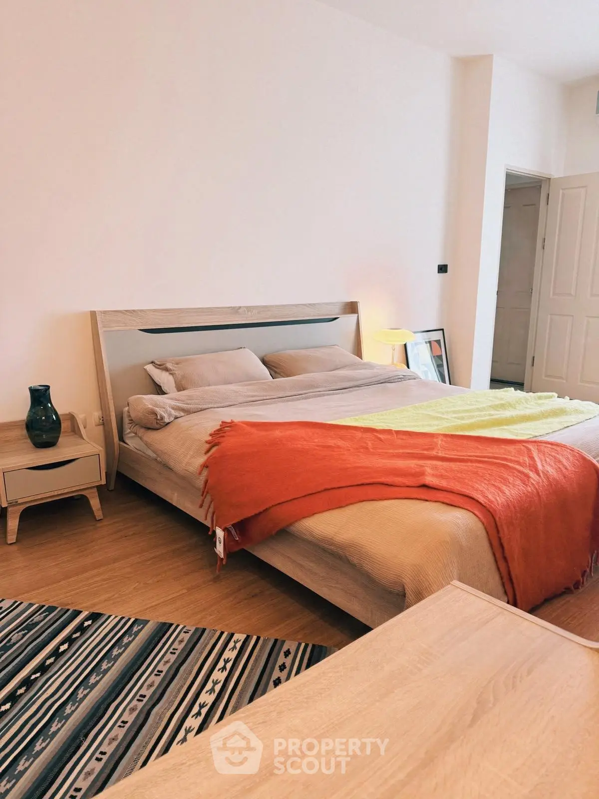 Cozy bedroom with modern decor and vibrant accents in a stylish apartment.