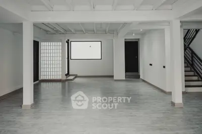 Expansive and versatile living space with polished floors, high ceilings, and a modern staircase, perfect for personalizing your dream home.
