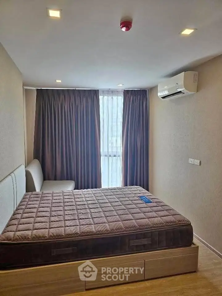 Cozy bedroom with modern air conditioning and stylish curtains, perfect for restful nights.
