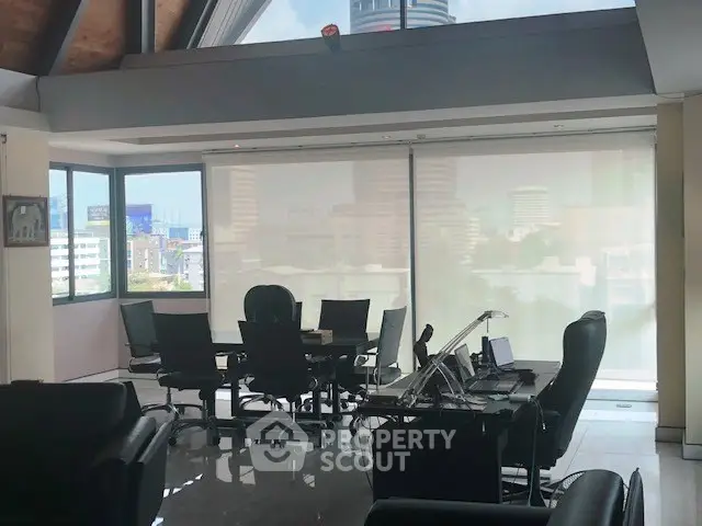 Spacious office space with modern furniture and city view, ideal for professional meetings.