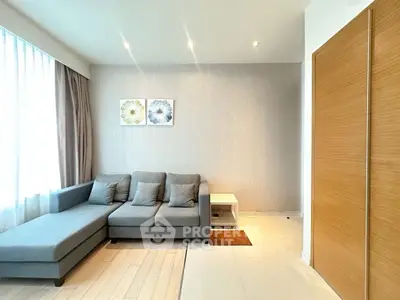 Modern living room with stylish gray sofa and elegant decor, featuring natural light and cozy ambiance.