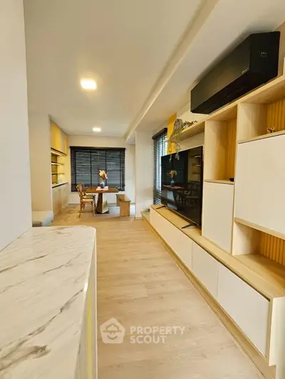 Modern living room with sleek design, featuring built-in storage and stylish decor, perfect for contemporary living.