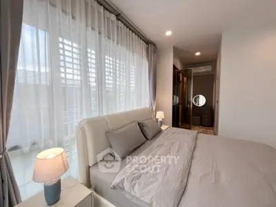 Luxurious bedroom with elegant decor and natural light, featuring a plush bed and stylish lighting.