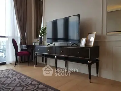 Elegant living room with modern TV stand and stylish decor, featuring large windows and luxurious curtains.